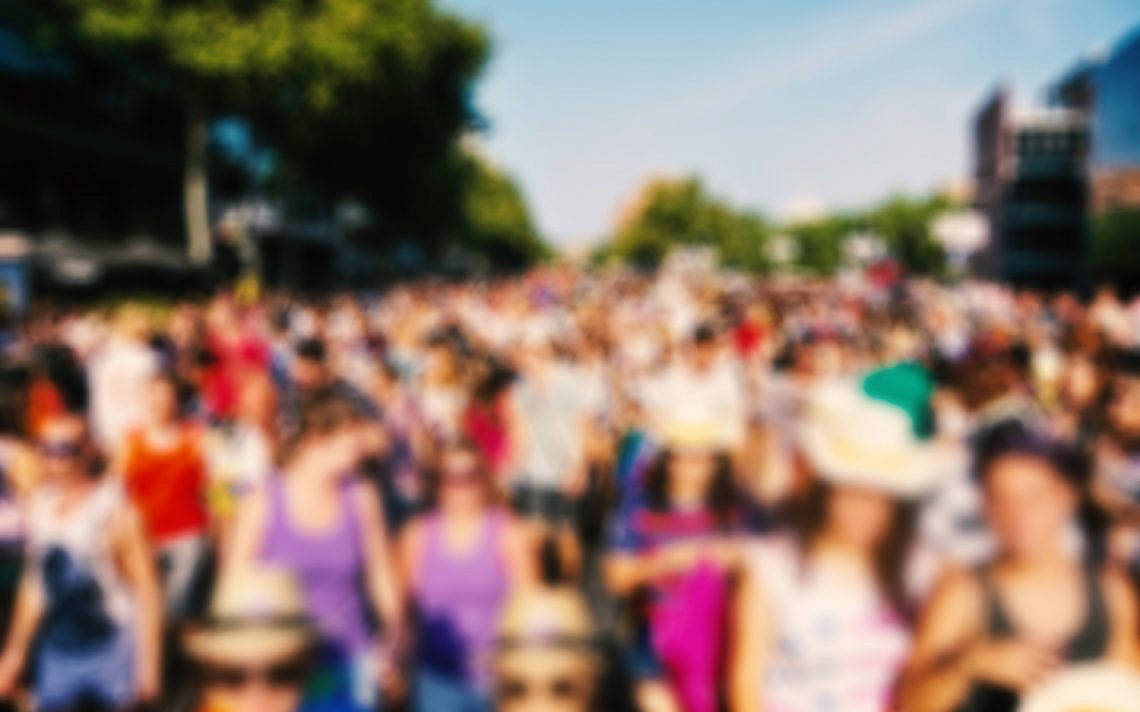 defocused background of a crowd of people partying or marching in a protest or in a parade outdoors